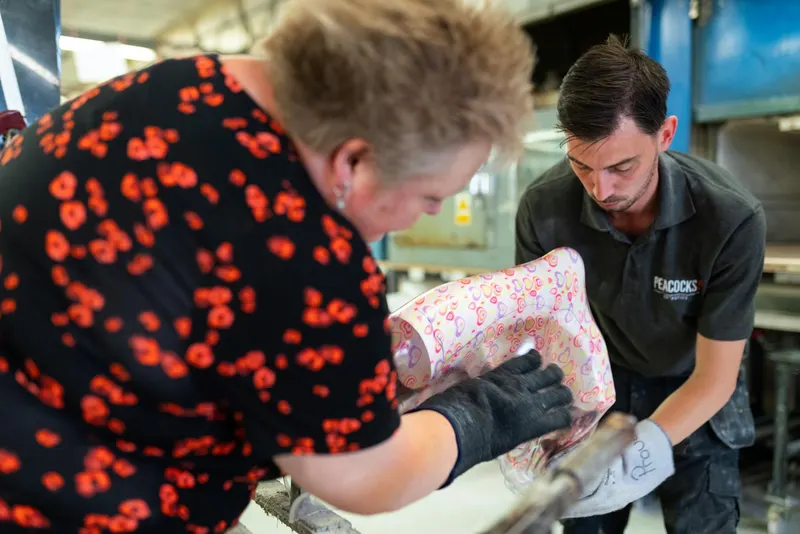 Two technicians focus on crafting a colorful orthotic brace in a workshop.